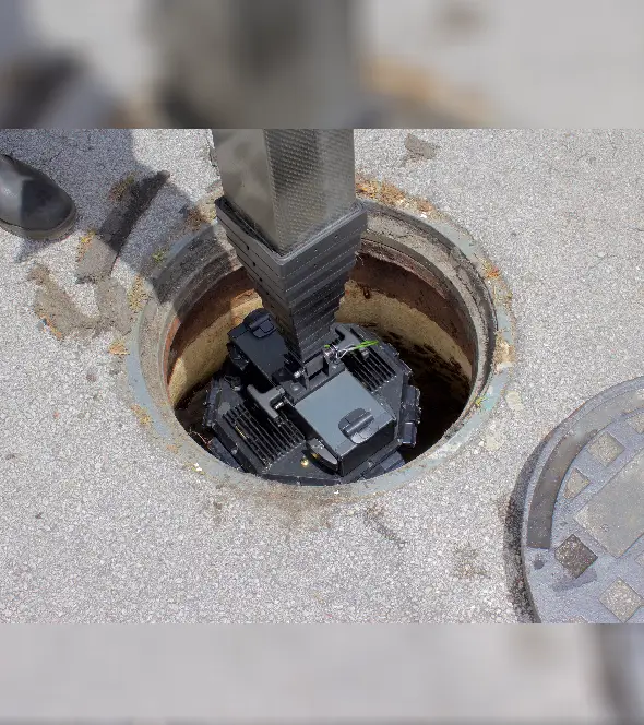 A manhole with electronic equipment installed inside.